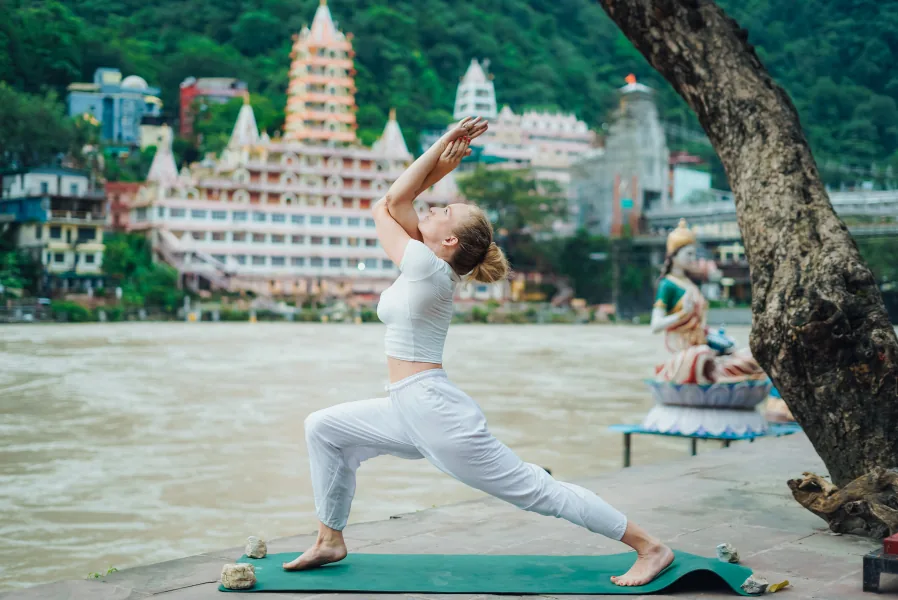 Mira Yogashala students practising yoga together beside the Ganga in Rishikesh